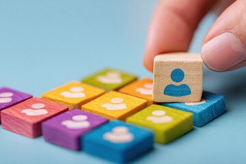 Hand placing a small wooden block with a person icon onto a grid of similar blocks