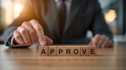a person pointing at the word APPROVE spelled out on wooden blocks, symbolizing a concept of consent or endorsement