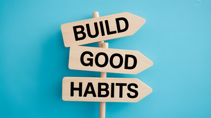 Directional signs displaying a motivational phrase to build good habits for success and self improvement