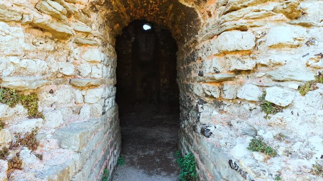 Inside the Roman lighthouse within the grounds of Dover Castle, Dover, Kent, England, UK, with stone walls, narrow windows and soft light