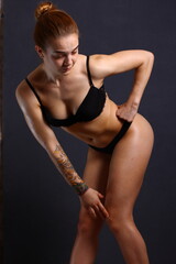 Obraz premium Beautiful young sexy cheerleader girl in black with tattoo on hand.