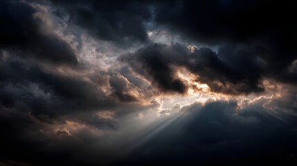 Dramatic sunbeams breaking through dark storm clouds illuminating the sky