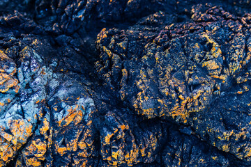 Abstract Close up mineral dark stone with rough surface and orange calcite embedded in the rock textures background. 