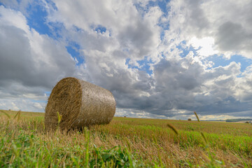 A Serene Hay Bale Nestled Under the Vast Swirling Cloudy Sky That Encompasses It