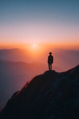 Obraz premium Silhouette of lone traveler standing mountain ridge glowing horizon backdrop epic adventure mood
