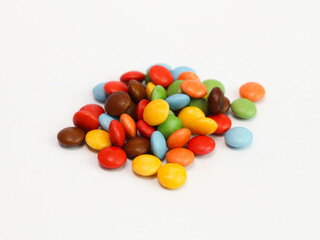 Colorful candy coated chocolate gems forming a vibrant border on white background