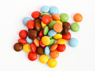 Colorful candy coated chocolate gems forming a vibrant border on white background