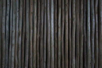 Rustic wooden palisade fence made of vertical logs in traditional design