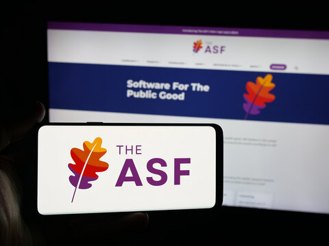 Stuttgart, Germany - 10-08-2025: Person holding smartphone with logo of organisation Apache Software Foundation (ASF) on screen in front of website. Focus on phone display.