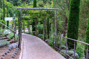Footpath with flowers and plants canopy at the Gardens of Trauttmansdorff Castle near Merano, South Tyrol, Italy