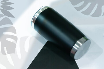 Black Insulated Stainless Steel Tumbler on Monochromatic Tropical Leaf Background