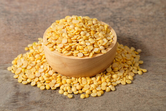 Split soybeans in a wooden cup and on a wooden table. Healthy food concept.