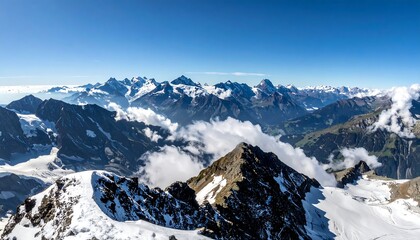 Panoramic view of snow-capped mountain peaks under a vast blue sky
