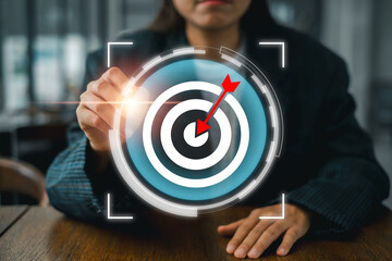 Businesswoman interacting with a digital target interface, symbolizing precision, success, and goal achievement in a modern business context.