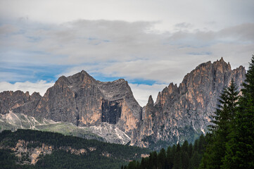 moutain Catinaccio range seen from Pozza di Fassa with a cloudy sky in the background, Val di Fassa, Trento, Italy