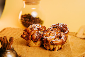 Delicious cinnamon rolls on a wooden platter with warm colors in the background