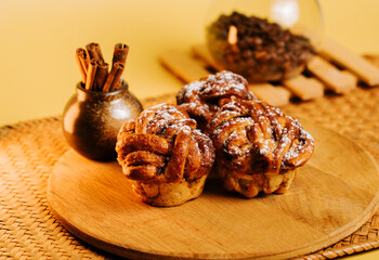 Baked pastries on a wooden plate with spices in a cozy kitchen setting