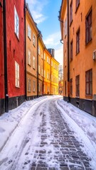 Snow-covered cobblestone street between colorful buildings