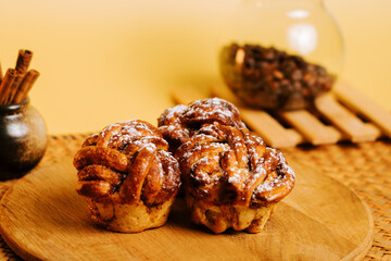Delicious cinnamon rolls displayed on a wooden board with coffee beans in the background