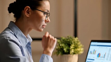 Focused businesswoman analyzing financial data and charts on laptop for corporate planning and performance management  
 - Powered by Adobe