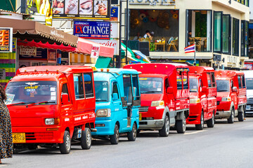 Colorful public transportation tuk tuks cars taxis in Phuket Thailand.