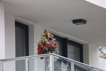 Artificial red roses bouquet on balcony railing