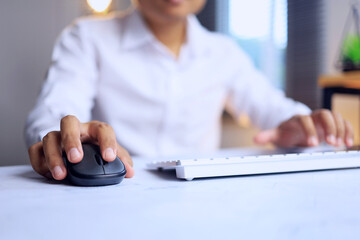 office desktop concept with a man in white shirt clicking mouse and typing on key board while working on work table