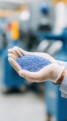 Close-Up of a Hand Holding Blue Plastic Pellets in a Manufacturing Environment, Highlighting the Importance of Raw Materials in Production Processes