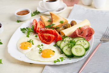 English breakfast - fried egg, salami, cheese, tomatoes, cucumbers and toast.