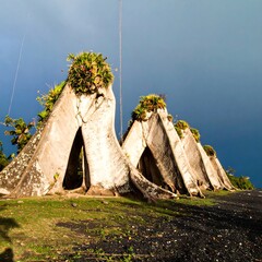 Weathered concrete structures with plant life under cloudy sky
