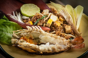 Traditional Thai Pad Thai with river prawn and banana blossom served on rustic wooden background