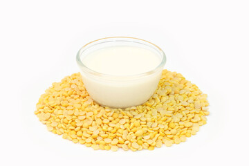 Soy milk in a glass cup and hsoybeans on a wooden table. Healthy food concept.