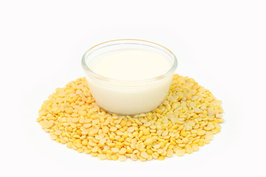 Soy milk in a glass cup and hsoybeans on a wooden table. Healthy food concept.