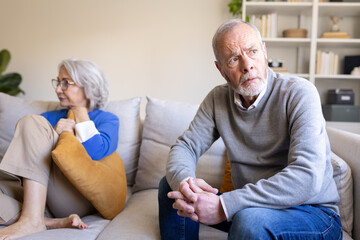 Senior couple having relationship problems sitting on sofa at home. ignoring each other.