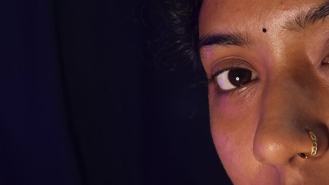 Closeup half face shoot of Indian teenage girl looking at camera with background isolated on black