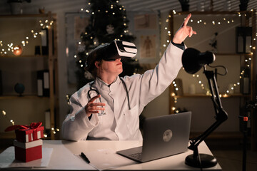 Young female doctor wears Santa Claus hat and vr googles watching at metaverse reality on the shift working at night on Christmas Eve. Medicine, holidays, futuristic technology and virtual reality