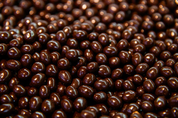 close-up of chocolate-coated nuts, glistening. A sweet dessert or snack background