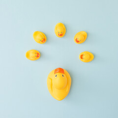 Group of rubber ducks around big duck on pastel blue background. Creative concept of teamwork, family and togetherness.