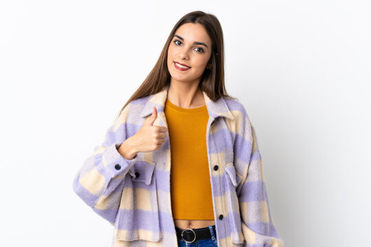 Fototapeta Young caucasian woman isolated on purple background giving a thumbs up gesture