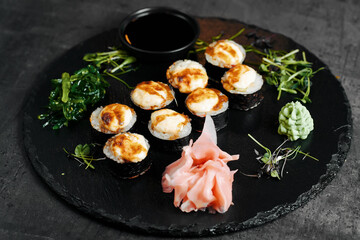 Round slate plate with sushi rolls and ginger top view
