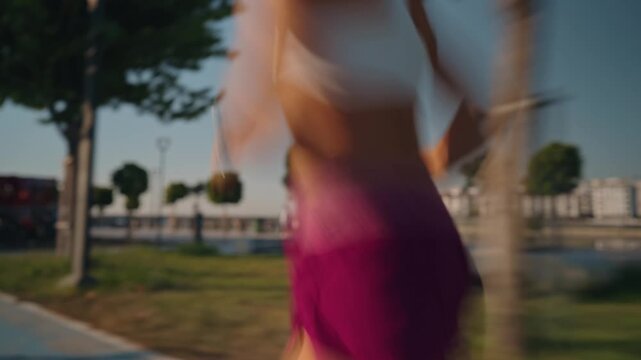 Dynamic close-up of a woman's legs in motion, running on a wet park trail. Captured with a slow shutter for motion blur effect. High quality 4k footage