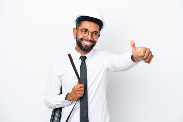 Young architect Brazilian man with helmet and holding blueprints isolated on white background giving a thumbs up gesture