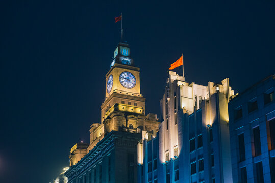 The illuminated Customs House clock tower at night, located on the historic Bund in Shanghai, China.
