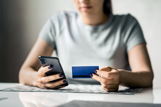 Credit card and phone for payment. Woman shopping and paying. Scam of fraud. Mobile transaction. Money in bank transfer. Purchase with smartphone app. Girl or student. using technology.