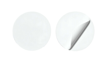 Two blank white circular stickers, one peeling. Black background. Light and shadow details