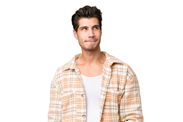 Obraz premium Young handsome caucasian man over isolated background having doubts while looking up