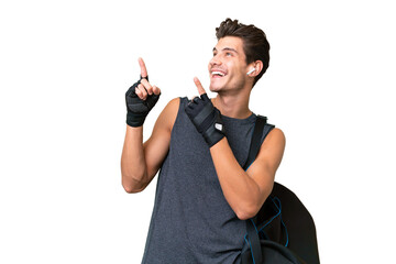 Young sport caucasian man with sport bag over over isolated background pointing with the index...