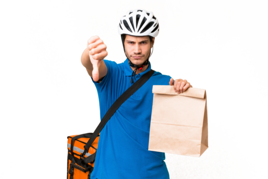 Young caucasian man taking a bag of takeaway food over isolated background showing thumb down with negative expression