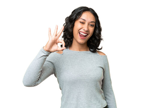 Young Argentinian woman over isolated background showing ok sign with fingers