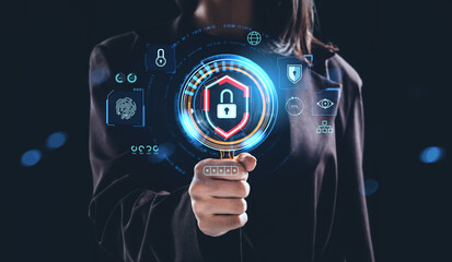 Woman holding digital padlock hologram with cybersecurity icons on dark background, representing data protection concept in futuristic interface design.